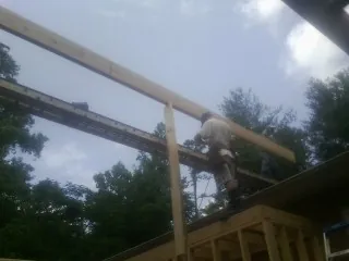 Carpenter setting a ridge beam over a new addition frame — Ice Dam Removal by Roofing Brothers in Sturgis