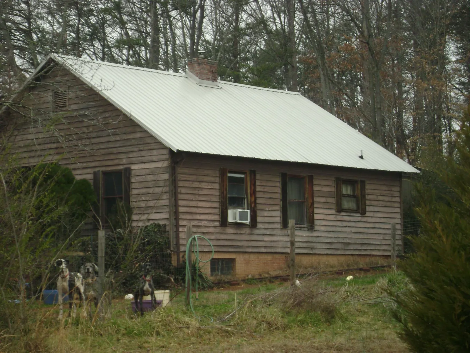White metal roof on an old wood sided farmhouse, from a Metal Roof Installation job in Sturgis